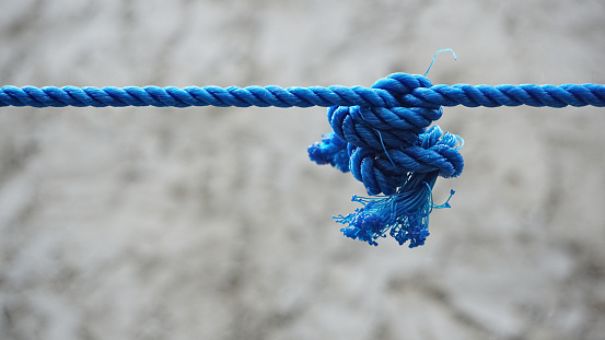 a blue rope tied tightly against a bokeh background