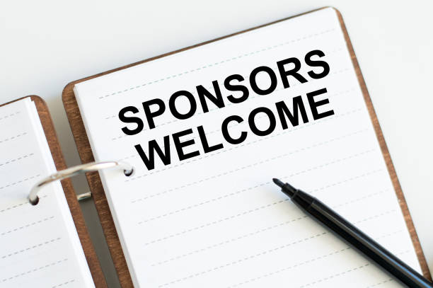 istock Sponsors Welcome text on an open notebook on a desk, a business concept 1369760719