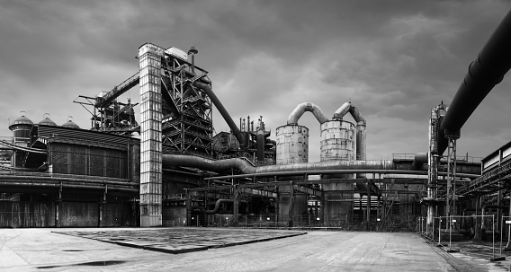 Duisburg, Germany, February 9, 2022: Blast furnace gas plant with gas towers and gas pipes at a place covered with sandstone slabs in the former iron and steel works in the landscape park Duisburg, stitched high resolution panorama