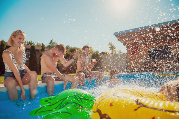 istock Friends having fun at the swimming pool 1369761584