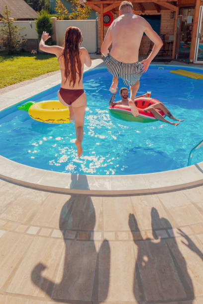 istock Couple jumping into the swimming pool 1369761668