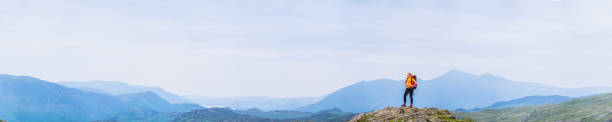 istock Woman hiker with backpack on mountain overlooking panoramic view 1369762497