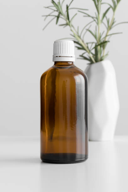 istock Pharmaceutical bottle mockup with a rosemary on the white table. 1369763064