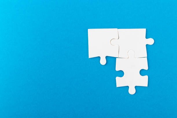 istock Jigsaw puzzle pieces on blue background. 1369763943