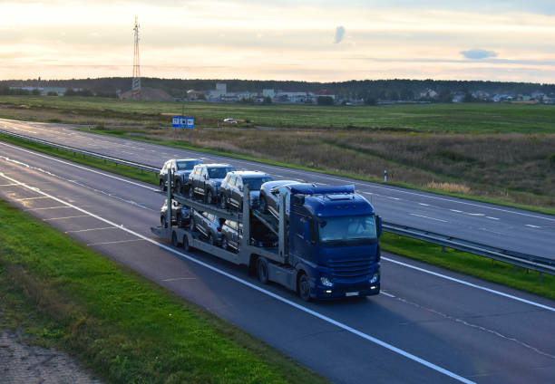 il rimorchio per auto trasporta auto in autostrada. concetto di servizi di trasporto auto e spedizione auto. - car car transporter carrying transportation foto e immagini stock