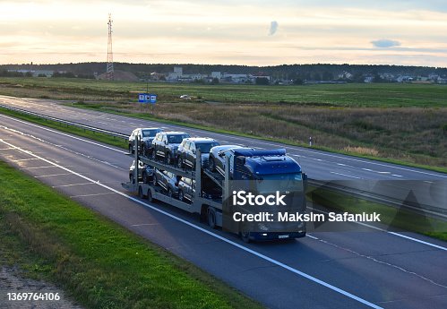 istock Car carrier trailer transports cars on highway. Auto transport and car shipping services concept. 1369764106