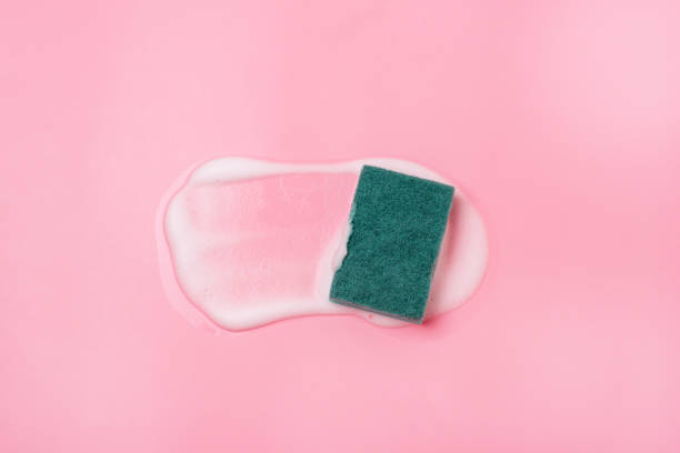 istock Cleaning Sponge and a Soapy Foam on a Pink Background Cleaning Concept Cleaning Service Banner Flat lay Top view 1369764328