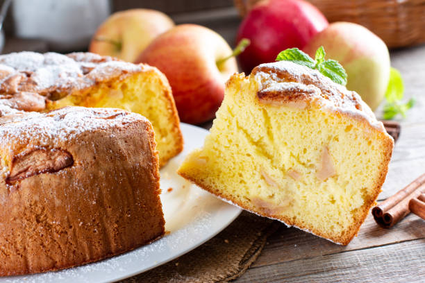 бисквитный торт или шифоновый торт с яблоками, такой мягкий и вкусный с ингредиентами: яйцами, мукой, яблоками на столе. концепция домашней � - бисквитный торт стоковые фото и изображения