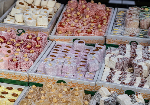 Turkish delight with various fillings, nuts and juice is sold in a pastry shop, various nuts and dry products are poured into containers, stand on the counter in a pastry shop.
