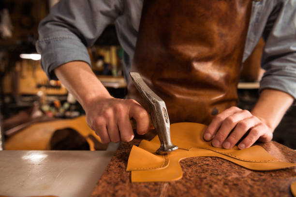 istock Close up of a cobbler working with leather 1369765816