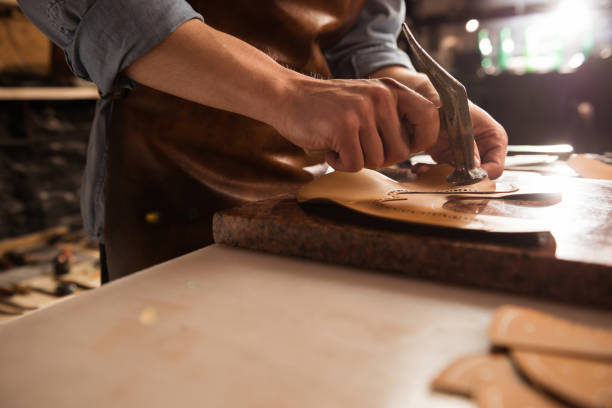 istock Close up of a shoemaker man working with leather 1369765843