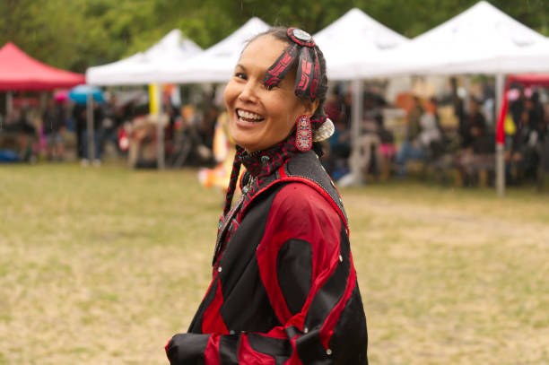 Pow Wow at Oppenheimer Park, dancer smiling at the camera Gathering of First Nations at Oppenheimer Park, Vancouver, British Columbia, Canada on 9 September 2017. Pow Wows are opportunities for First Nations to gather, honouring and sharing their heritage and traditions including music, dance and beautifully vibrant regalia. The general public is welcome. pow wow dancer stock pictures, royalty-free photos & images