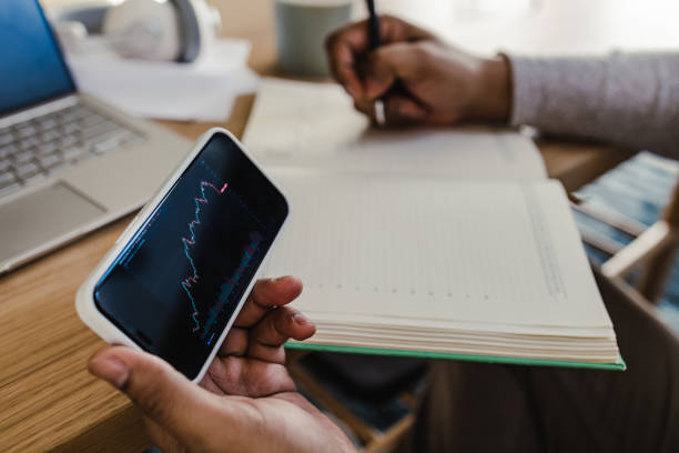 Man's hands holding mobile phone and analyzing crypto currency