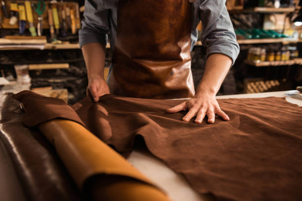 istock Close up of a cobbler working with leather textile 1369766021