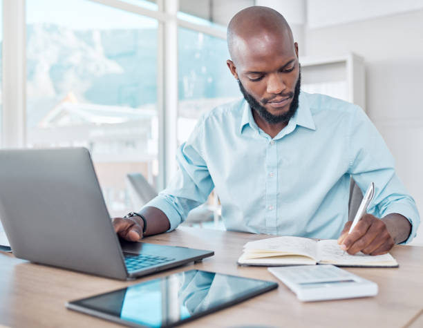 istock Shot of a young businessman making notes while working 1369766200