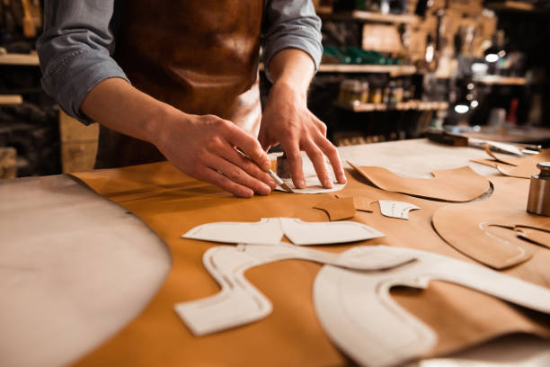 istock Close up of a shoemaker measuring and cutting leather 1369766361