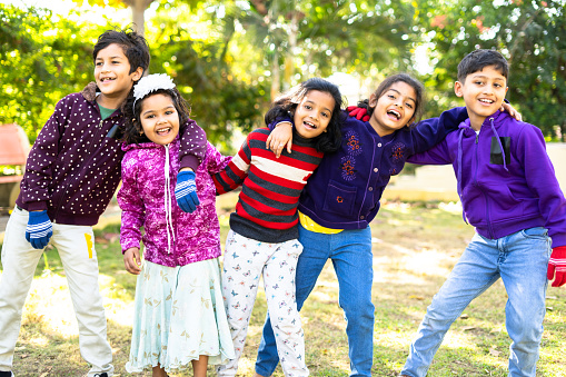 Indian teenager kids enjoying or spending time with friends by dancing at park - concept of celebration, picnic, winter vacation and leisure activities