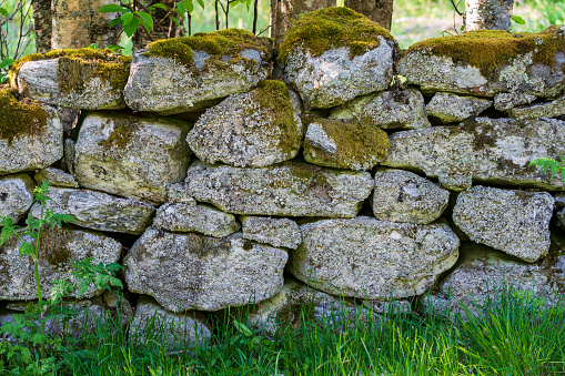 VALLDAL, NORWAY - 2020 MAY 30. Dry Stone Wall with moss in the nature.
