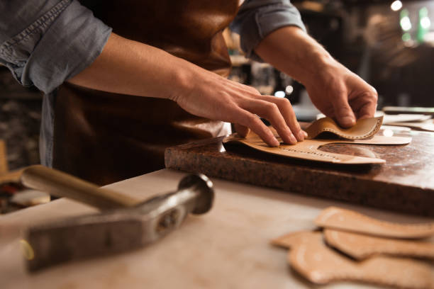 istock Close up of a cobbler working with leather 1369767433