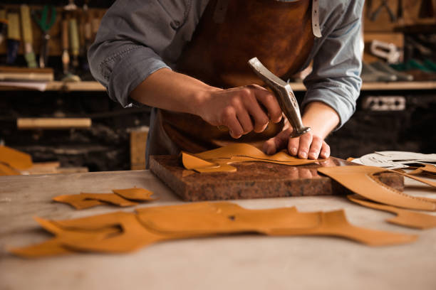 istock Close up of a shoemaker man working with leather 1369767467