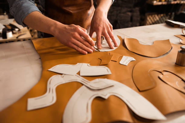 istock Close up of a male shoemaker cutting leather textile 1369767804