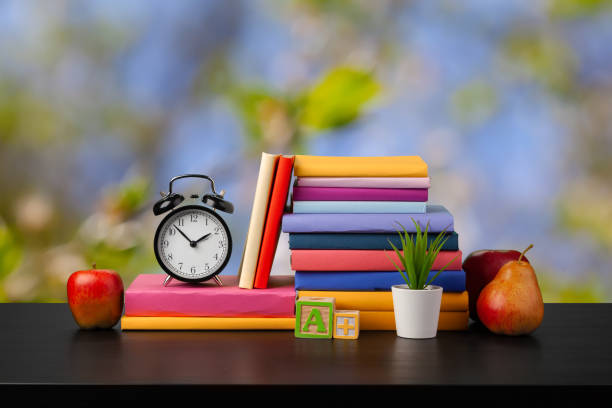 istock Stack of books on wooden table against blurred background 1369768781