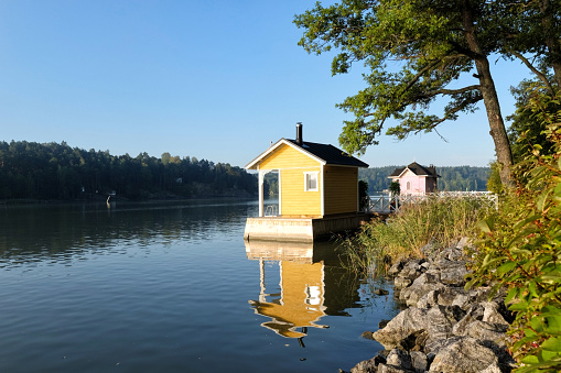 Turku, Finland - August 10, 2019: Two traditional Finnish wooden sauna log cabins by the sea on early summer morning.