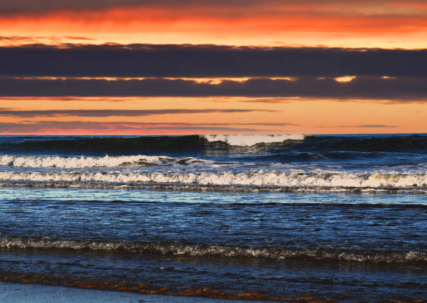 ondas no mar em um fundo dramático do pôr do sol. ondas no mar durante tempestade e vento. - wave salt surf sea - fotografias e filmes do acervo