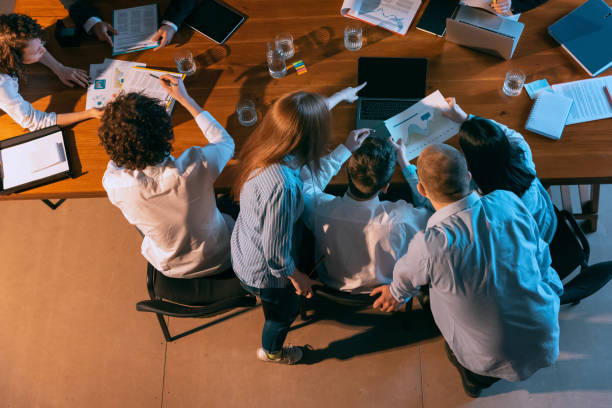istock Top view of business conference, meeting. Young colleagues, co-workers, students during work process at office, indoors. Startup, finance, tech and innovation concept. 1369769398