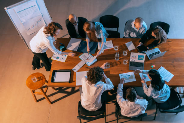 istock Aerial view of young multiethnic people talking, working with colleagues, co-workers at office, indoors. Work, finance, tech concept. 1369769421