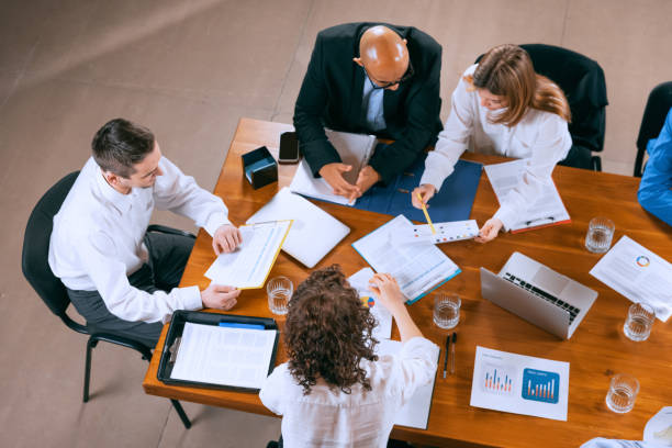 istock Top view of business conference, meeting. Young colleagues, co-workers, students during work process at office, indoors. Startup, finance, tech and innovation concept. 1369769435