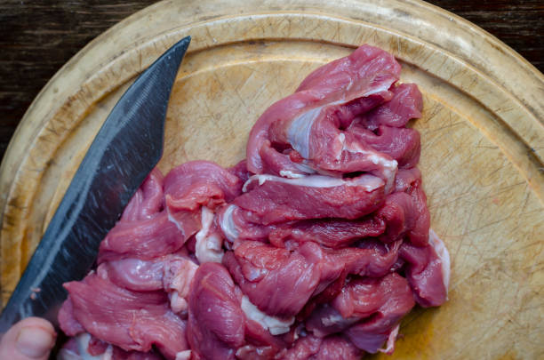 Strips of raw Beef Stroganoff on a wooden cutting board. Kitchen knife. Selective Focus.