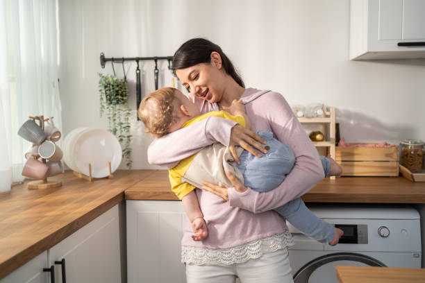 kaukasische liebende mutter hält baby junge kleinkind, um ihn in den schlaf zu wiegen. attraktive mutter trägt kleinen kleinen sohn mit sanfter und zärtlicher für einen gesunden tagesschlaf im haus. mutterschaft-eltern-konzept. - baby beautiful little boys carrying stock-fotos und bilder