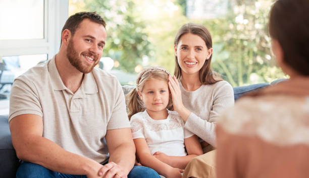 снимок молодой семьи, обсуждающей с кем-то дома - teacher parent education meeting стоковые фото и изображения