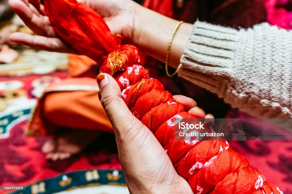 Indian women twist silk cloth Indian women twist silk cloth. Preparing for wedding tradition ceremony. Culture of India Stock Photo