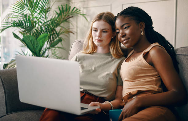 istock Shot of two young friends spending time together while using a laptop 1369773426