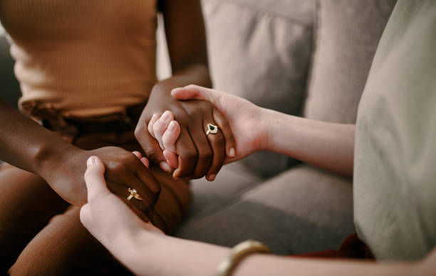 istock Shot of two friends holding hands supporting one another 1369773724