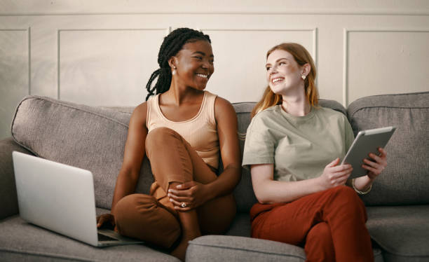 istock Shot of a two friends spending time together while using a digital tablet and laptop 1369774173
