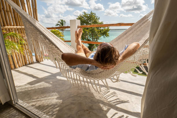 istock Young man relaxing in an hammock on a balcony 1369774908