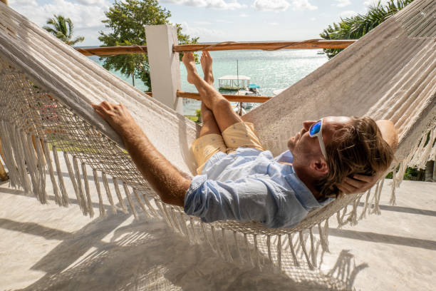 istock Young man relaxing in an hammock on a balcony 1369774995