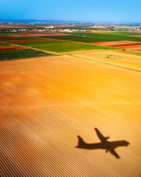 istock Airplane casting shadow over newly plowed land in Seville 1369775152