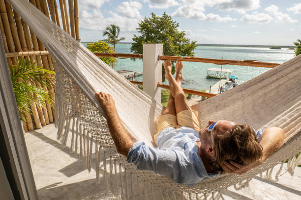 istock Young man relaxing in an hammock on a balcony 1369775553