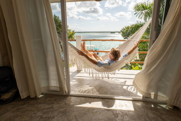 istock Young man relaxing in an hammock on a balcony 1369775749