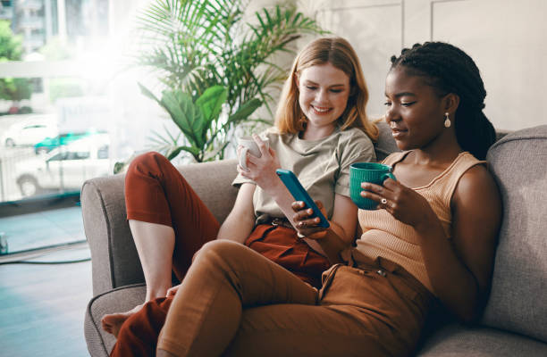 istock Shot of two friends catching up over coffee while using a smartphone 1369775883