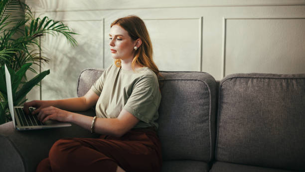 istock Shot of a young woman working from home using her laptop 1369775954