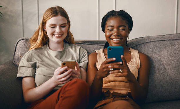 istock Shot of two friends relaxing while using a smartphone 1369776980