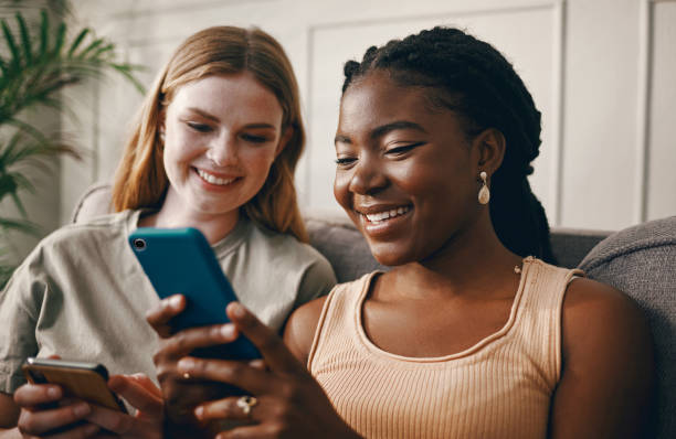 istock Shot of two friends relaxing while using a smartphone 1369776983