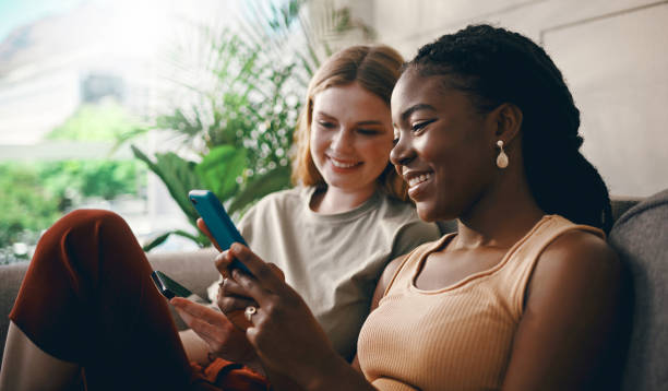istock Shot of two friends relaxing while using a smartphone 1369776985