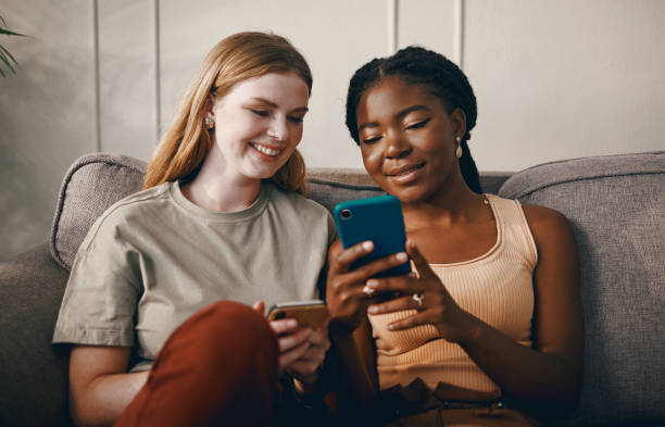 istock Shot of two friends relaxing while using a smartphone 1369776994