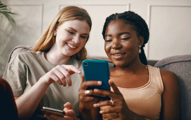 istock Shot of two friends relaxing while using a smartphone 1369776997